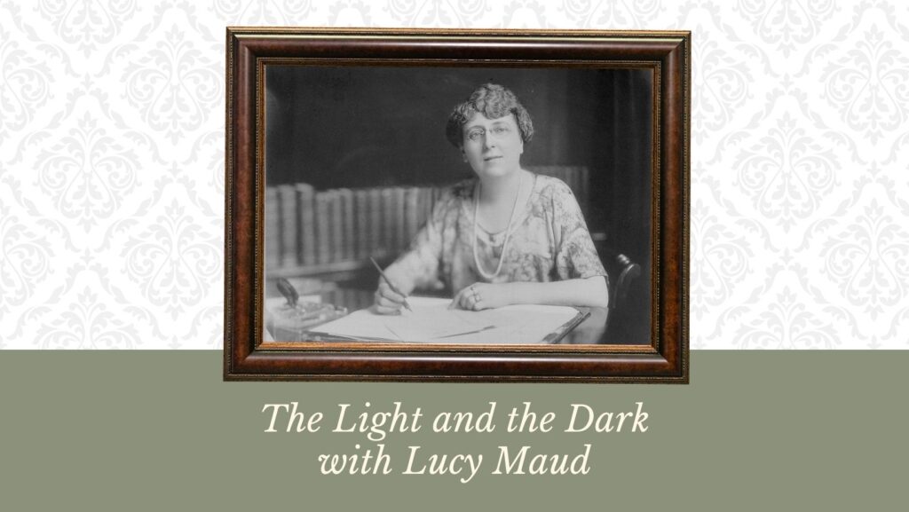 A black and white image is framed on this graphic, with Lucy Maud Montgomery sitting at a desk, pen in hand, papers and books surrounding her.